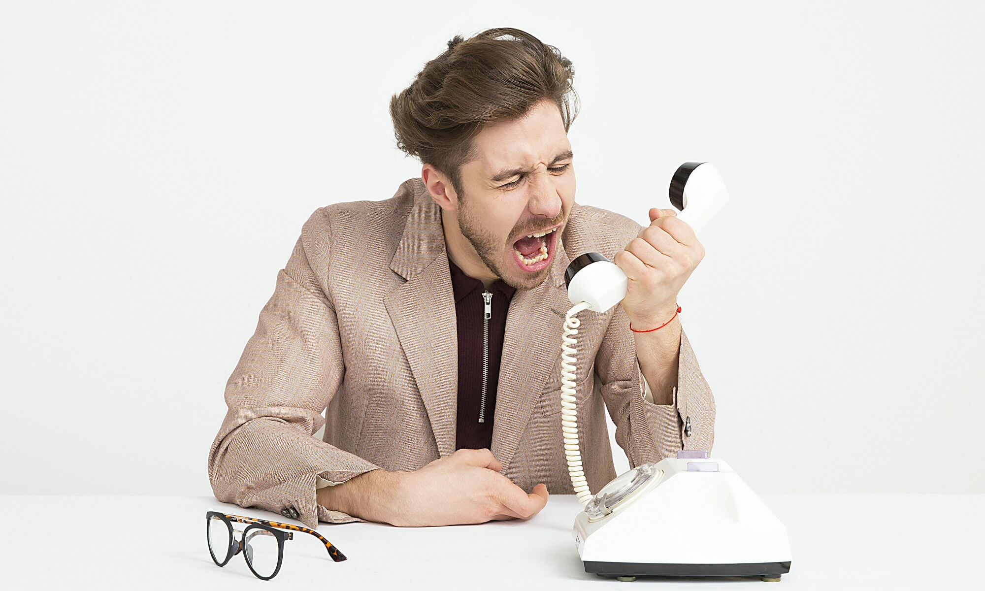 Photo of a man annoyed shouting at the telephone.